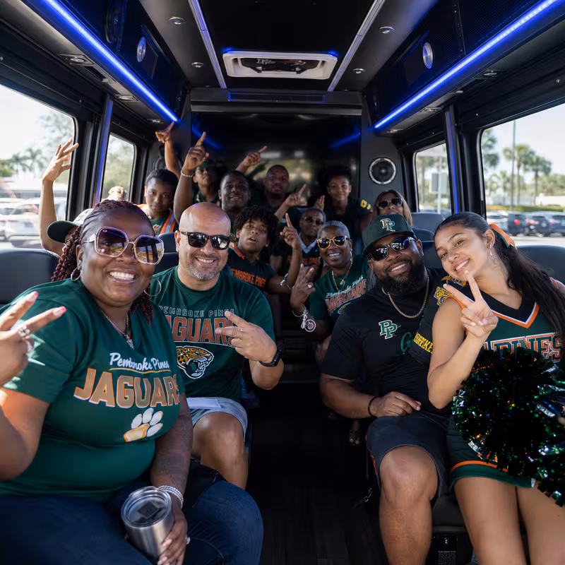 Group boarding a white charter bus for Sporting Event Transportation transportation in Pembroke Pines